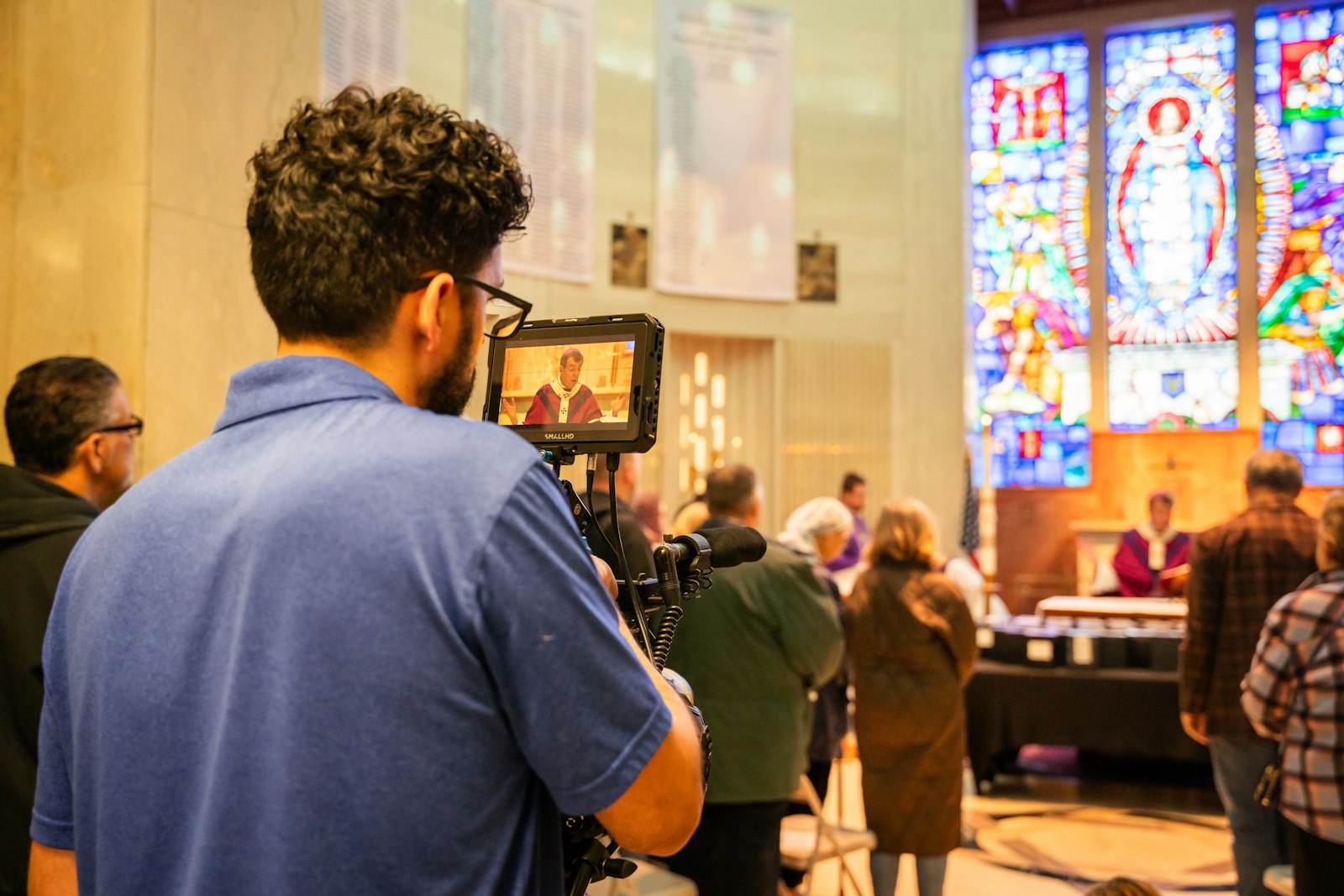 A member of Famie's production company, Visionalist Entertainment Productions, films the All Souls Day Mass as part of the upcoming documentary. (Valaurian Waller | Detroit Catholic)