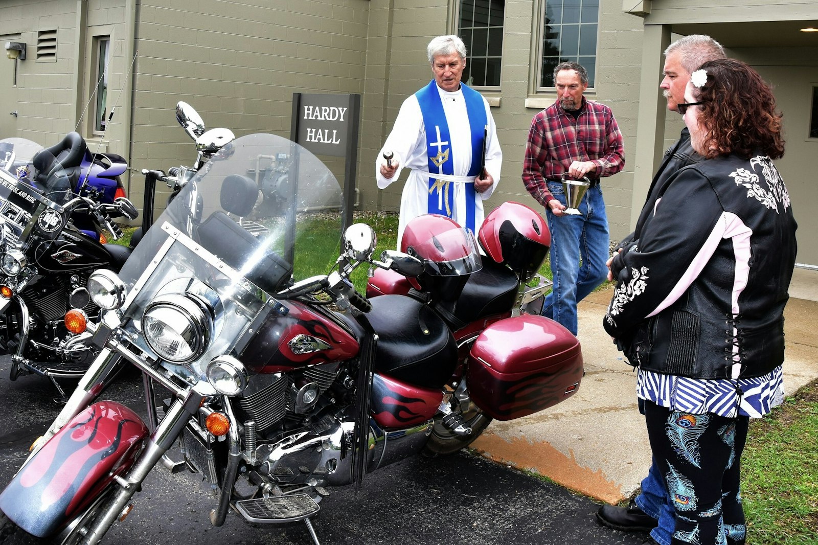 Fr. Frawley blesses a motorcycle at St. Anne Parish in Ortonville. The Irish-born priest loved sports, especially golf and hurling, a sport popular in his native country. (Courtesy photo)
