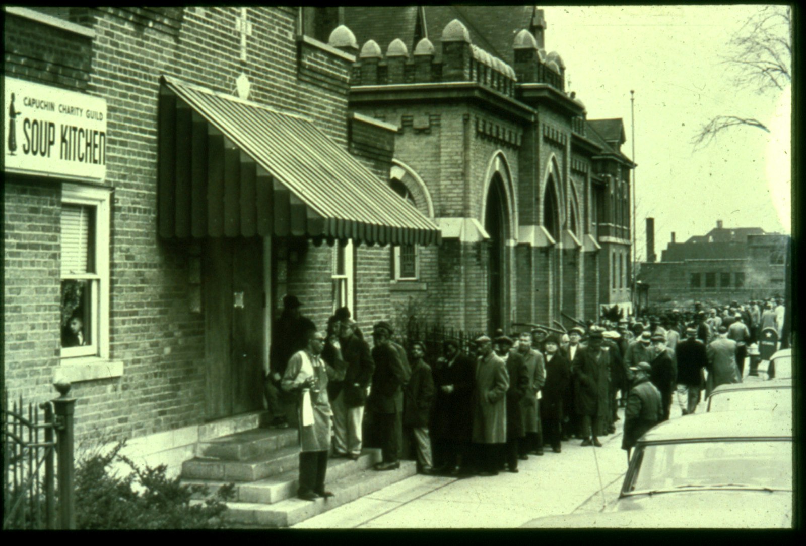 Lines wrap around the original soup kitchen building on Mount Elliott Street next door to the chapel at St. Bonaventure Monastery in this undated photo. The Solanus Casey Center now occupies the spot where the original Capuchin Soup Kitchen was established in 1929. (Photo courtesy of the Capuchin Franciscan Province of St. Joseph)