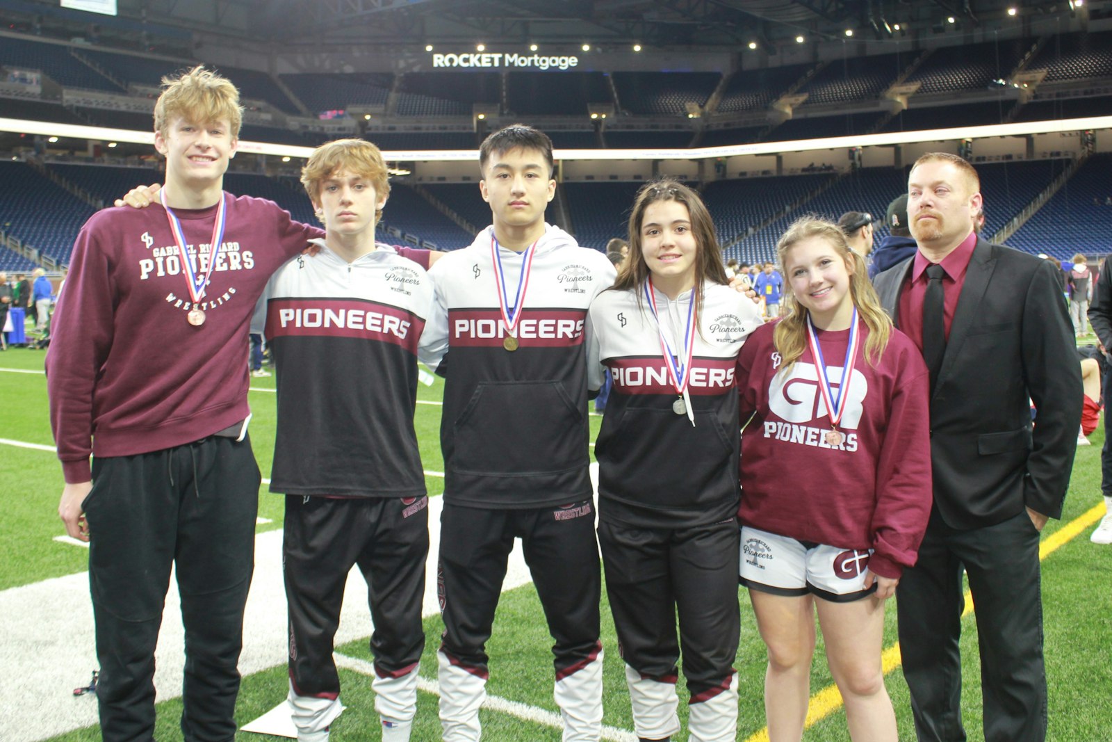 With five all-staters from a team of 13 athletes, Gabriel Richard’s wrestlers must be doing something right.  Joey Calhoun, Luke Harrington, Sebastian Martinez, Rihanna Venegas and Jacey Barnabei show off their championship medals, along with coach Derek Zambon.
