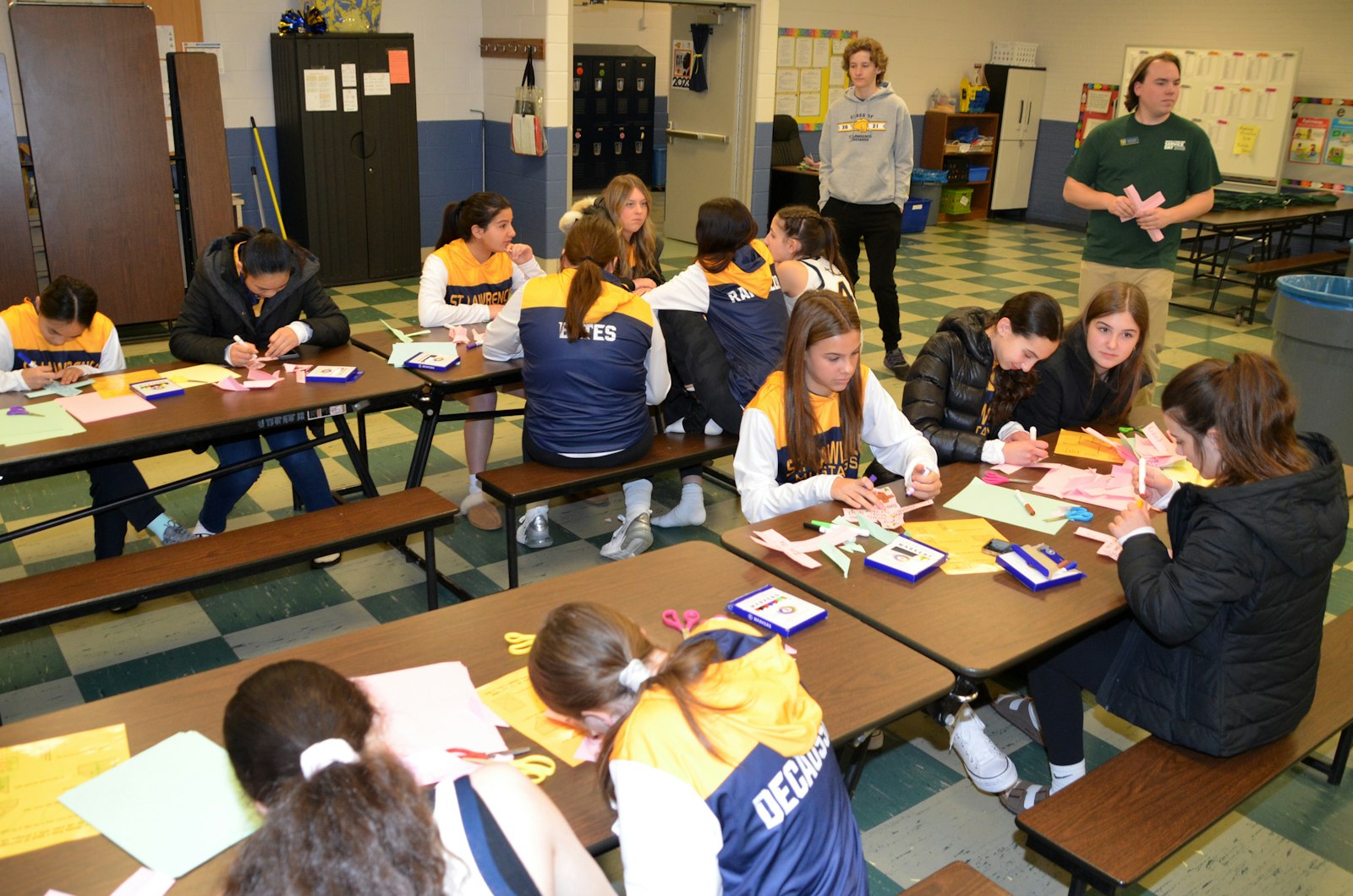 St. Lawrence varsity girls' basketball players create their crosses before their game against St. Hugo on Jan. 14.