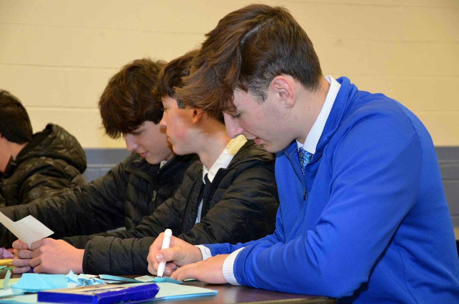 Griffin Bluthardt (right), an eighth-grader and basketball player from St. Hugo Elementary School, said the service project was "pretty cool" adding that writing prayers in conjunction with Martin Luther King Day was a great way to "spread a good message." Beside him are fellow eighth-graders and varsity basketball players Henry Dietz (center) and Griffin Delusky.