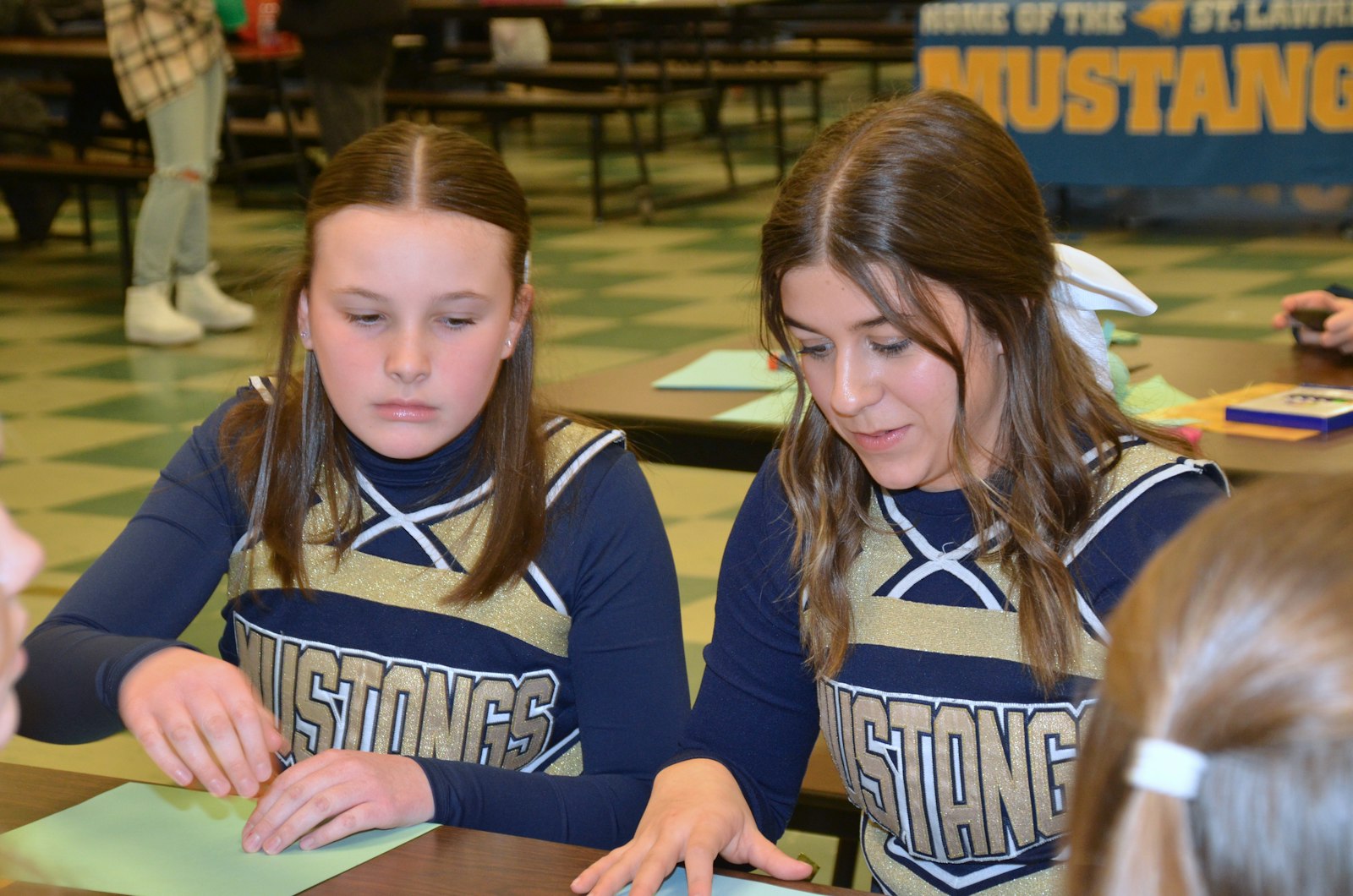 Ashley Royse (left) and Audrey Mesi, eighth-grade cheerleaders at St. Lawrence Elementary School, Utica, collaborate as they design their crosses as part of a service project for Martin Luther King Day.
