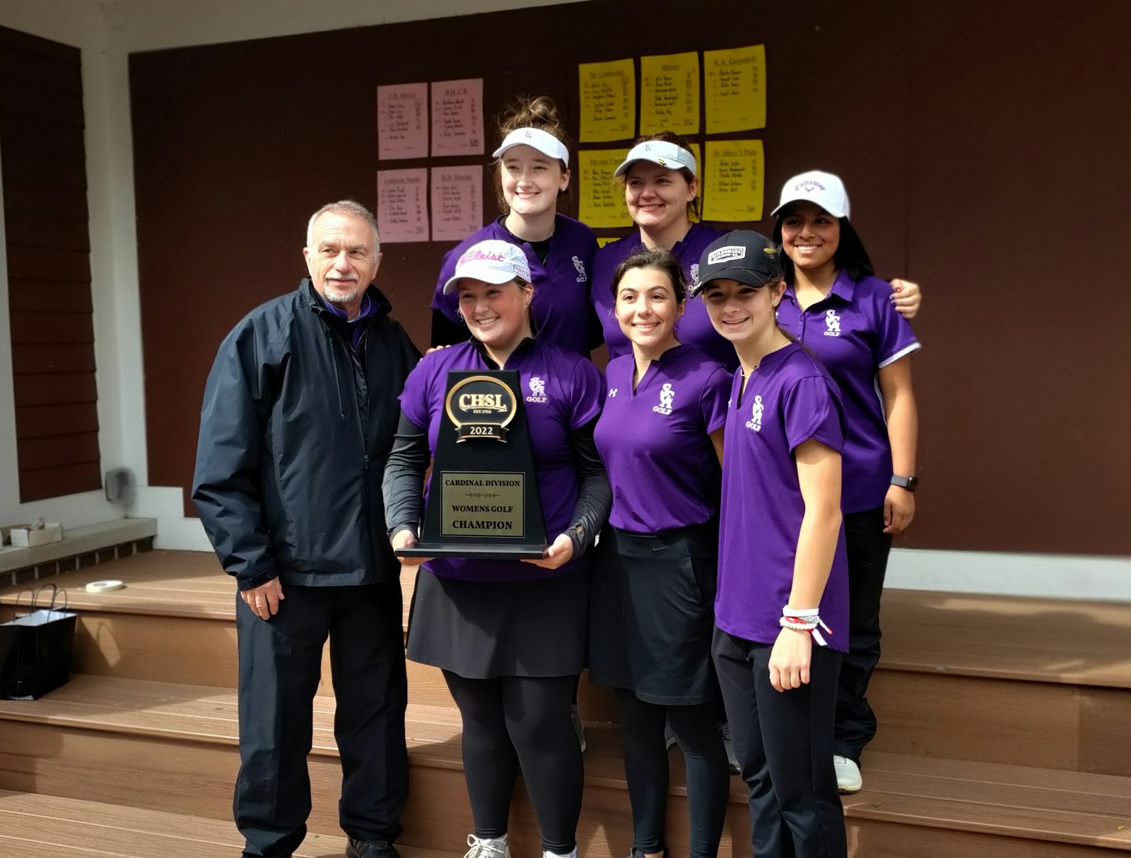 Rachel Fay holds the Cardinal Division trophy, the first Catholic League golf championship for St. Catherine of Siena. Her teammates are Joey McQuaid and Sydney Schafer in the front row, and behind them Brenna Cavanaugh, Abby Raben and Lucy Krichko. Orrin Tibbits has coached the sport at St. Catherine since its inauguration five years ago.