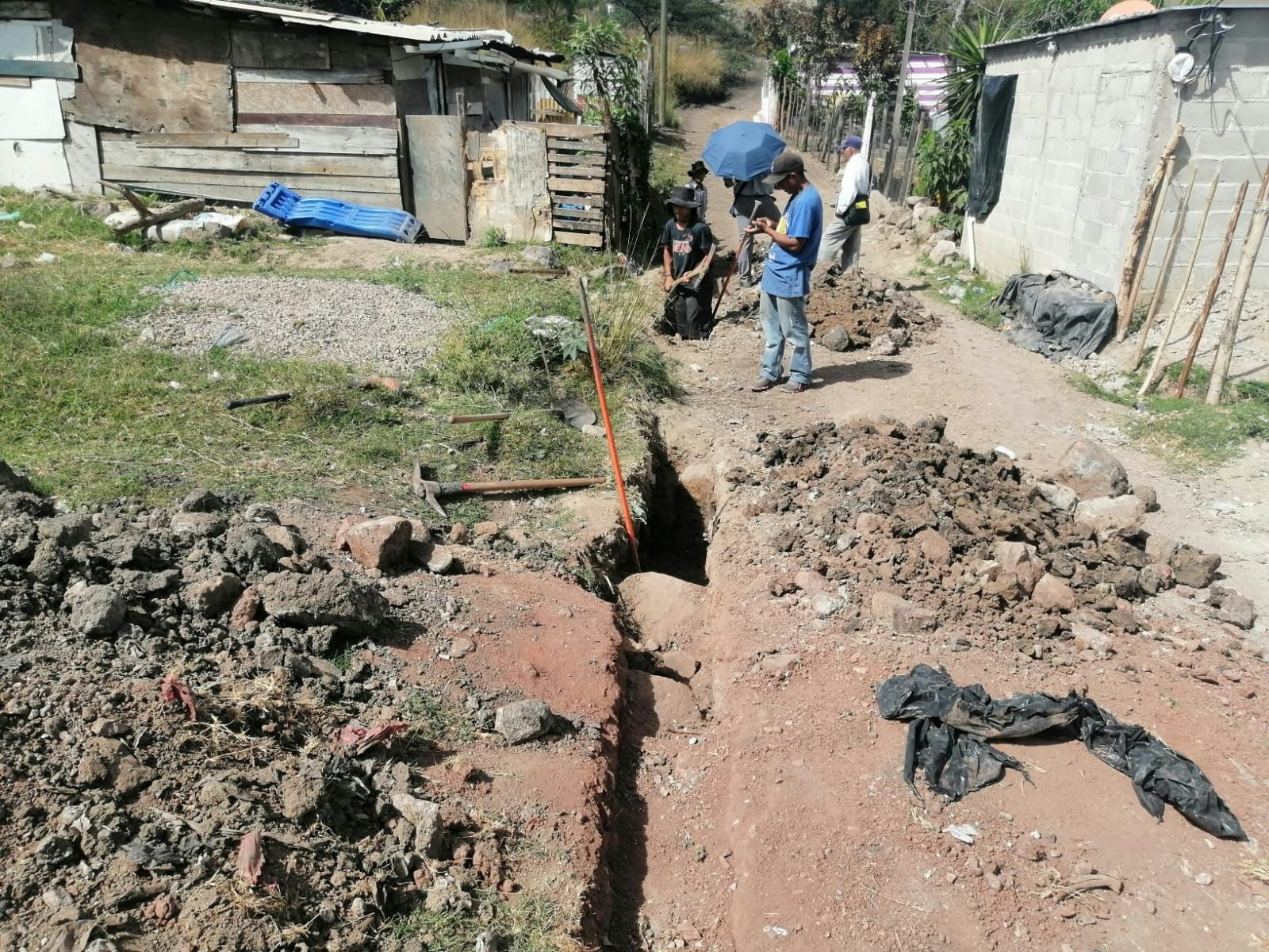 Los trabajadores cavan una zanja para la nueva torre de agua en la capital de Honduras.