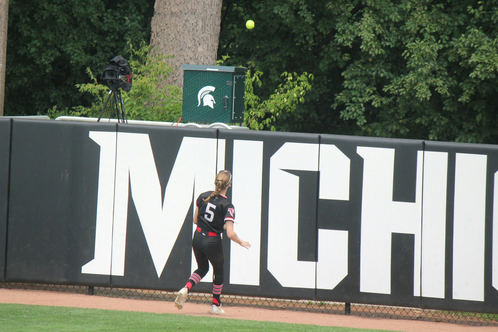 Right-fielder Alexis Hansen watches as a ball hit by Gaylord’s Alexis Kozlowski clears the fence at Michigan State University’s Secchia Stadium. The blast proved to the the game-winner in Gaylord’s 2-1 decision over Divine Child.