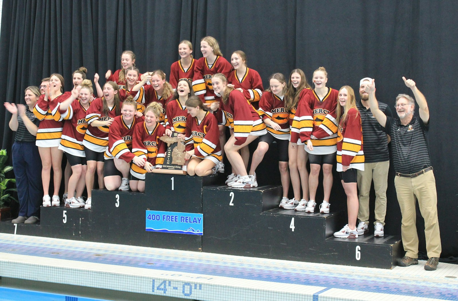 Mercy celebrates another state title on the winners’ stand. The Marlins only had three first-place finishes, but scored points in 11 out of the 12 events to win convincingly.