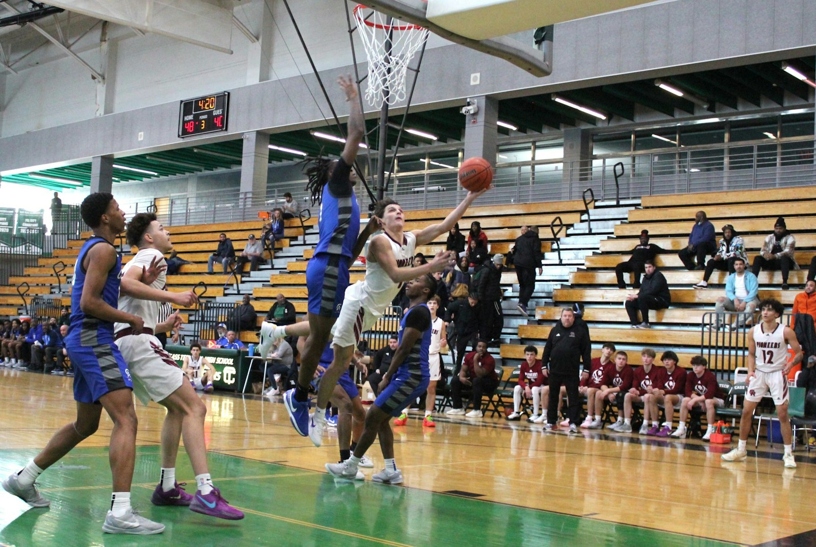 Nick Sobush goes for a scoop lay-up against taller Flint Carman-Ainsworth defenders. Gabriel Richard defeated Carman-Ainsworth 79-62 in a showcase game played at Detroit Cass Tech.