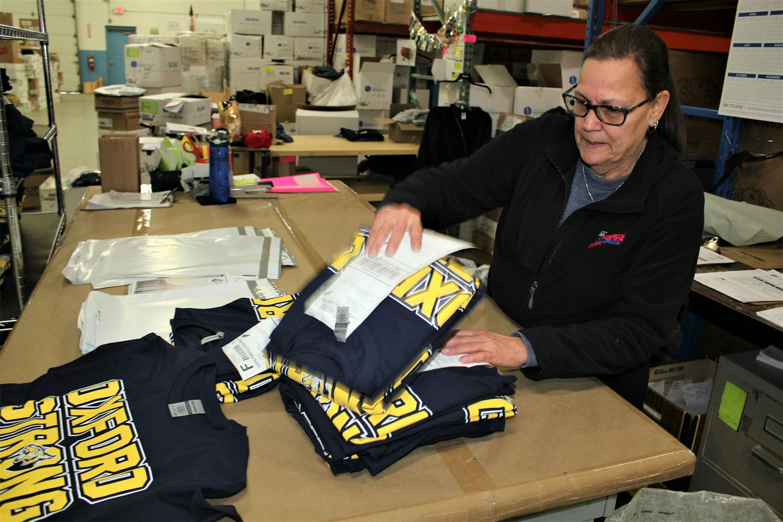 Carmen Ortiz of E.A. Graphics readies Oxford Strong shirt orders for shipping. Proceeds from the sale of the shirts will be donated to the Oxford Community Memorial and Victims Fund. (Photo by Wright Wilson | Special to Detroit Catholic)
