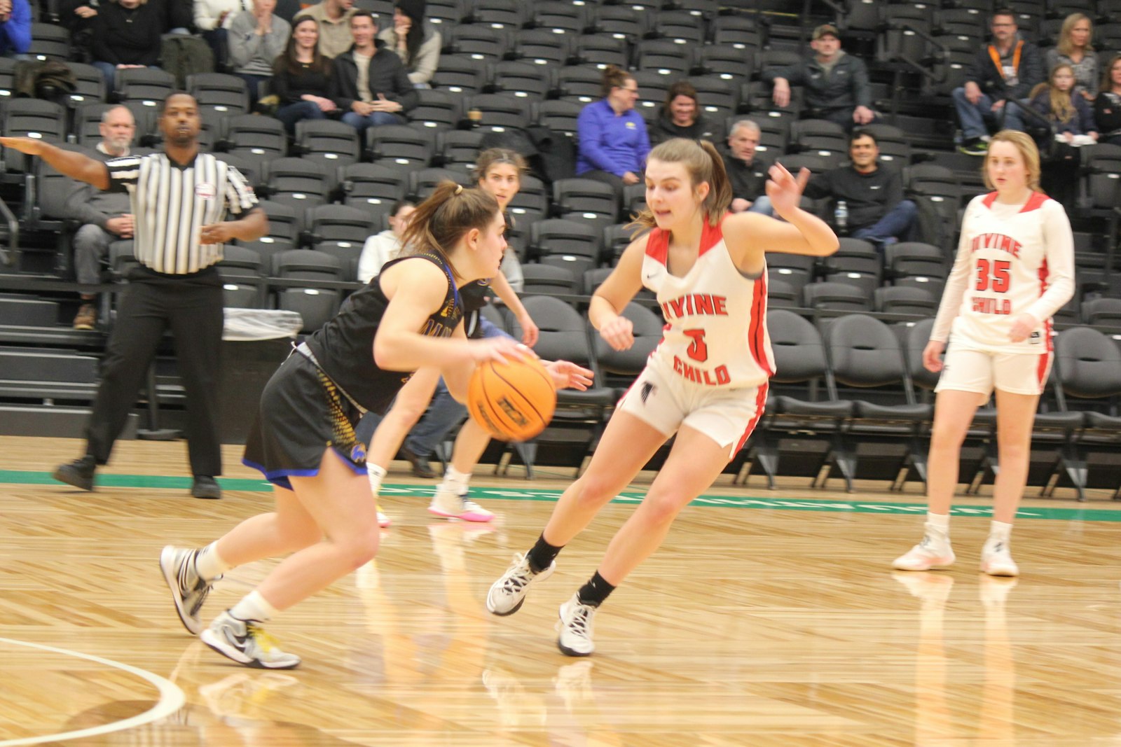 Marian point guard Anna Herberholz brings the ball up court against Divine Child’s Anna Bidolli. Herberholz scored 22 points — including all of her team’s 11 in the first quarter — pacing the Mustangs to a 44-38 win.