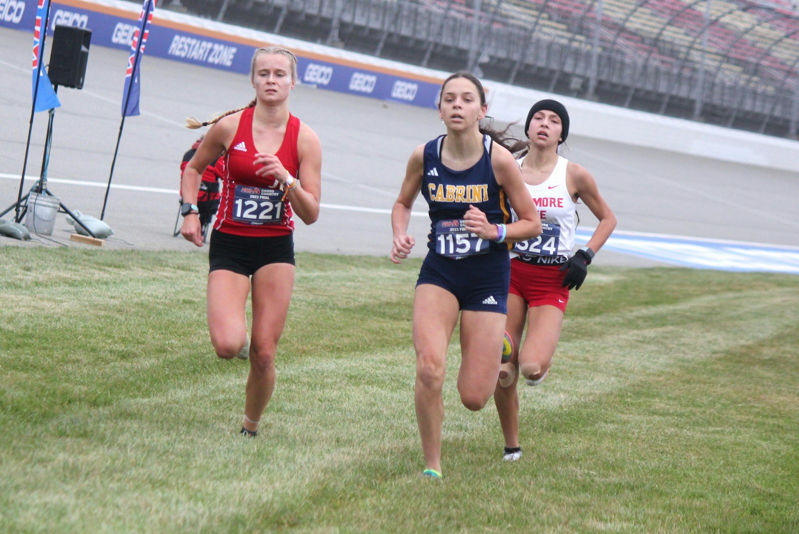 Sprinting to the finish, Allen Park Cabrini senior Ava Teed battles Johannesburg-Lewiston’s Allie Nowak and Whitmore Lake’s Carina Burchi. Teed finished fifth in the Division 4 girls race, netting her fourth all-state honor in as many seasons. (Wright Wilson | Special to Detroit Catholic)