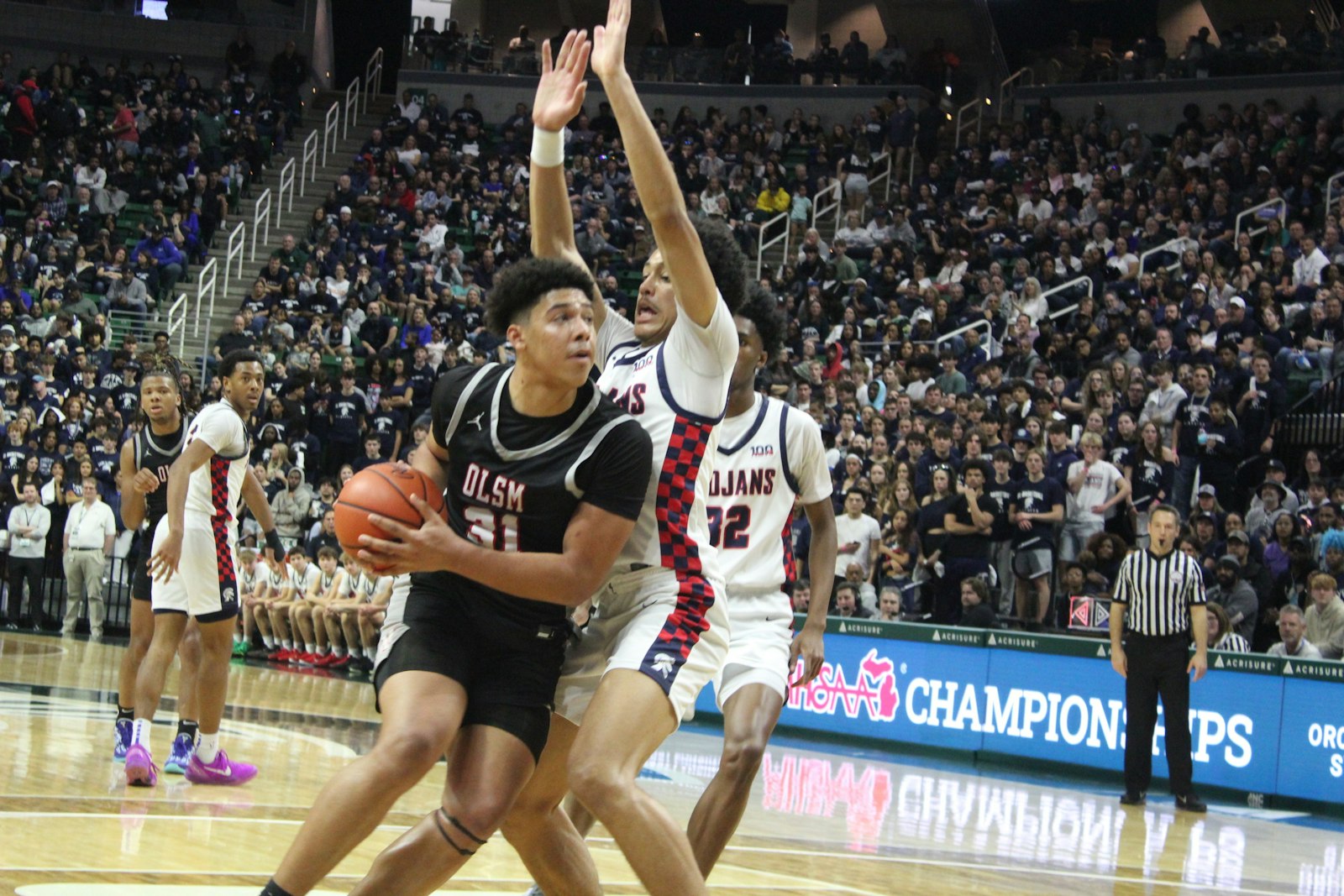 Jayden Savoury tries to drive for a shot against East Lansing defenders in the Eaglets’ semifinal loss in the state tournament.