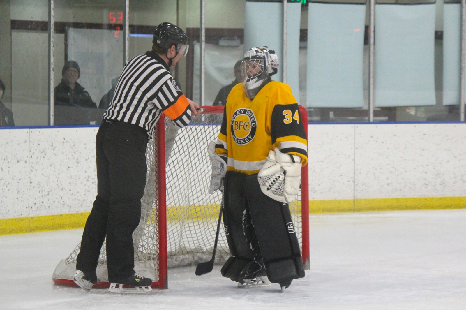 The referee has a word with goaltender Parker Stalcup, a junior from Clarkston Everest Collegiate.