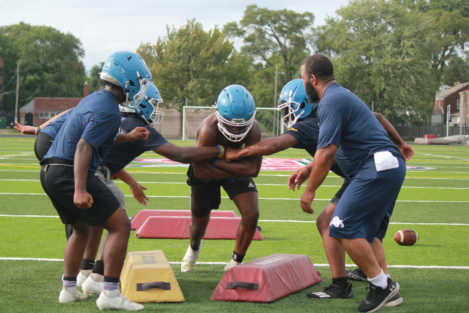 Loyola running backs work on a drill while practicing on the University of Detroit Mercy campus. The Bulldogs will open their season with a home game there on Aug. 26.