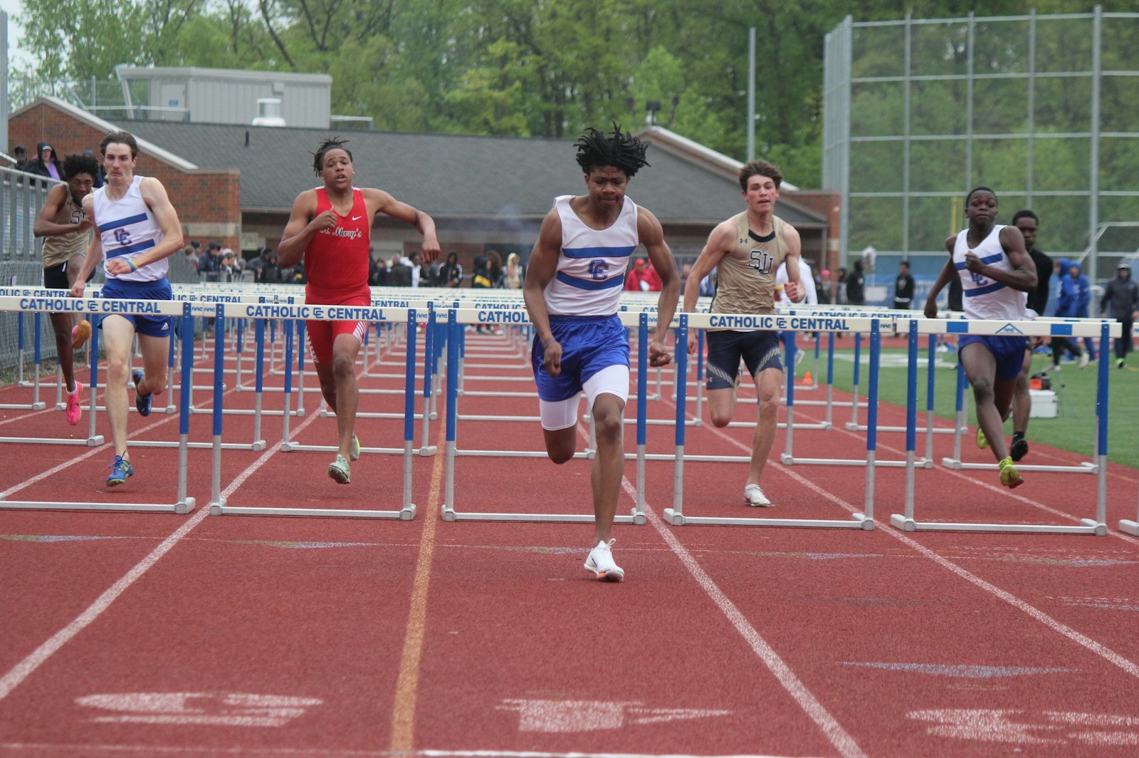 Novi Detroit Catholic Central’s Zacchaeus Brocks (center) set a new Catholic League record for the 110-meter high hurdles, running the race in 14.10 seconds. The old mark of 14.25 dated back to 1984.