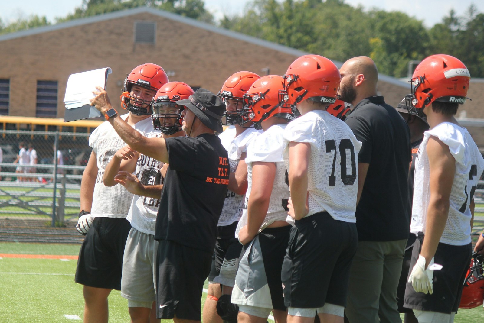 Brother Rice Offensive Coordinator Rich Popp holds up a page of the playbook for his athletes to see the next scheme.