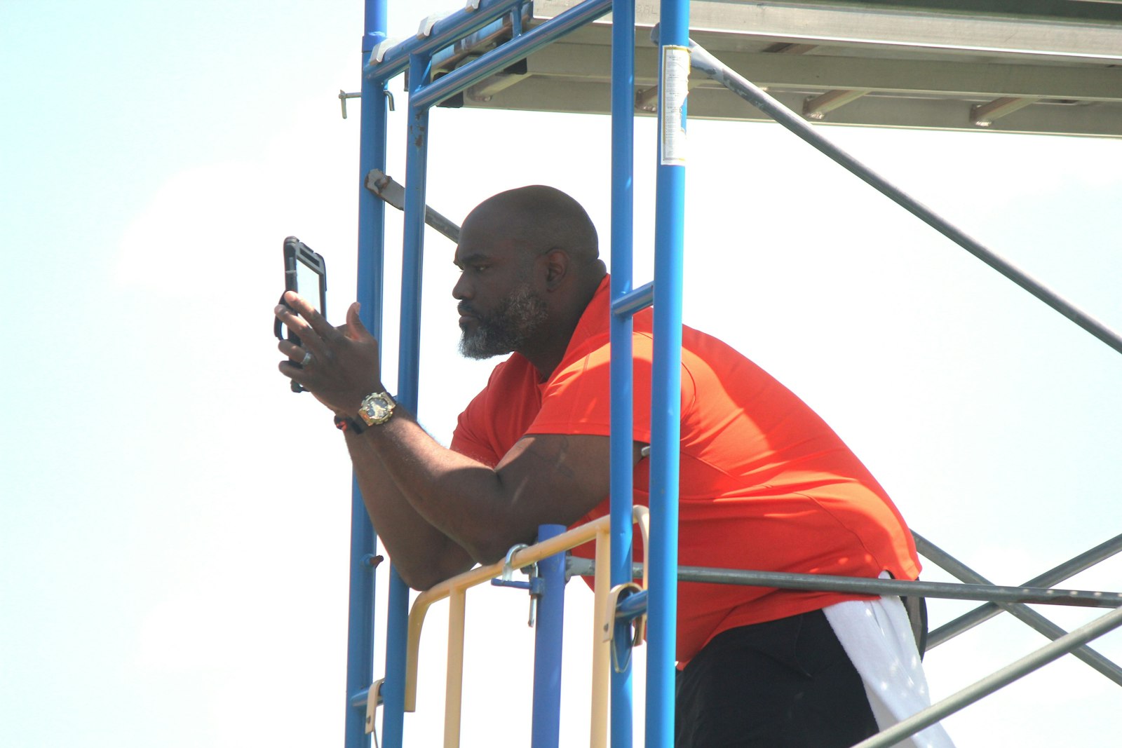 Perched high above the practice field on scaffolding, coach Aaron Marshall captures video of his squad running a play. Marshall joined Brother Rice after leading Southfield A&T to the Division 1 state title last fall.