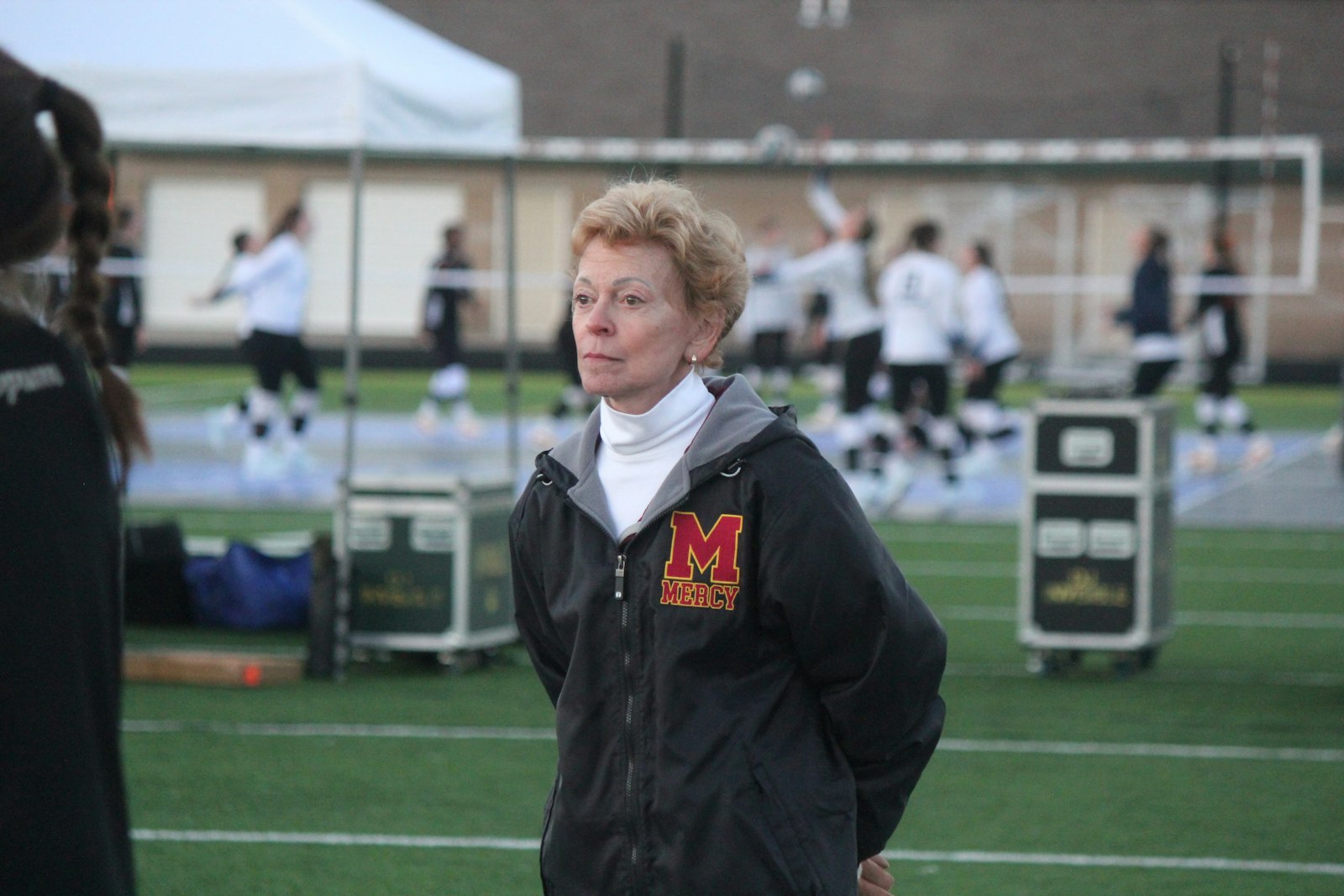 Mercy coach Loretta Vogel is clad in cold-weather gear while watching the Marlins scrimmage Grand Rapids Forest Hills Northern.