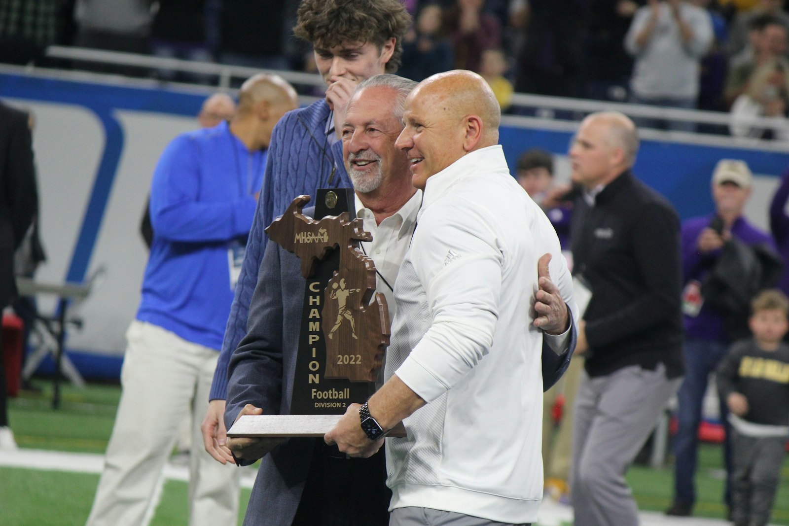 Winning coach Dan Rohn accepts the state championship trophy from Catholic High School League director Vic Michaels.