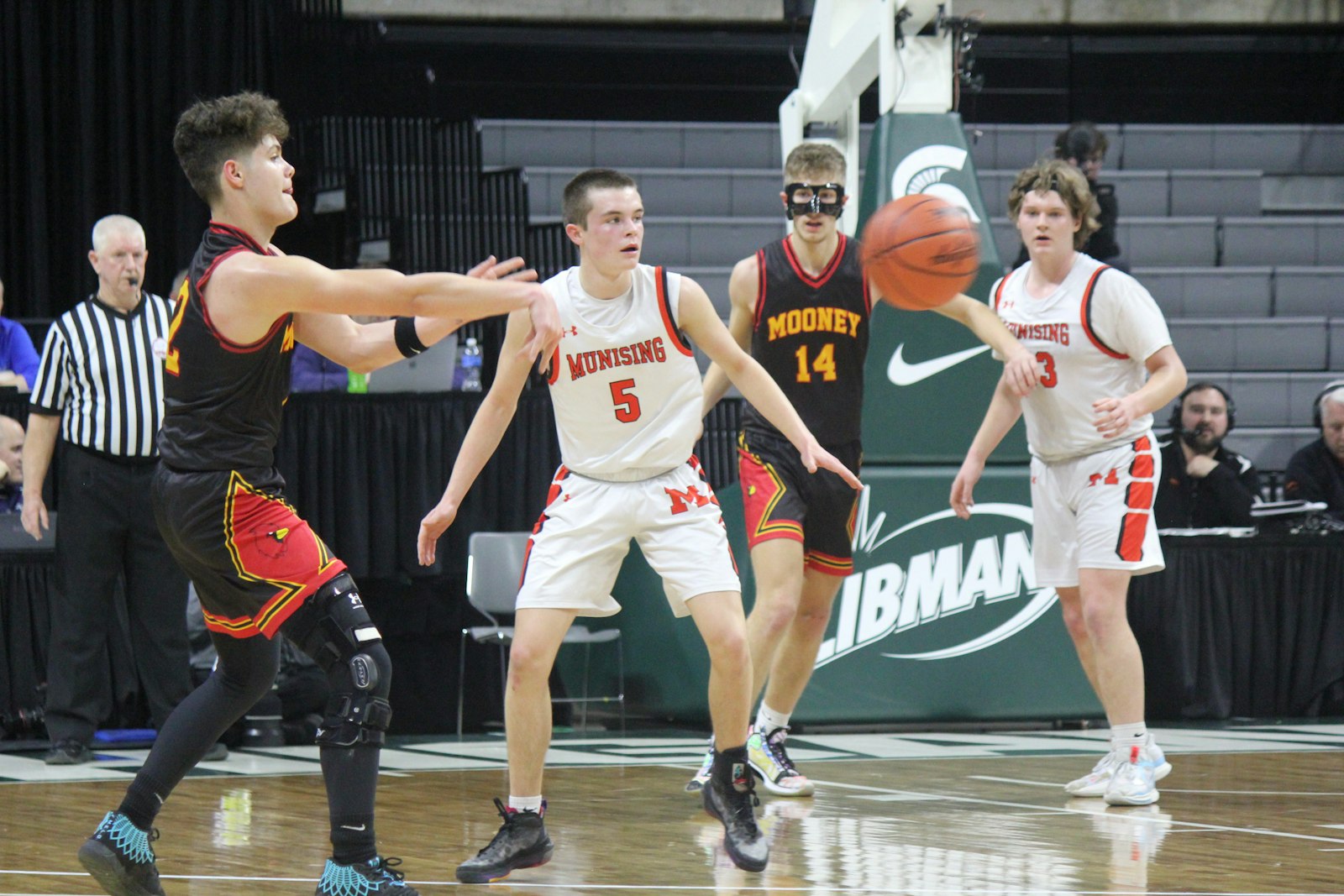 Guard Brian Everhart, wearing a heavy knee brace, spots an open Cardinal Mooney teammate during Thursday’s semi-final matchup with Munising.