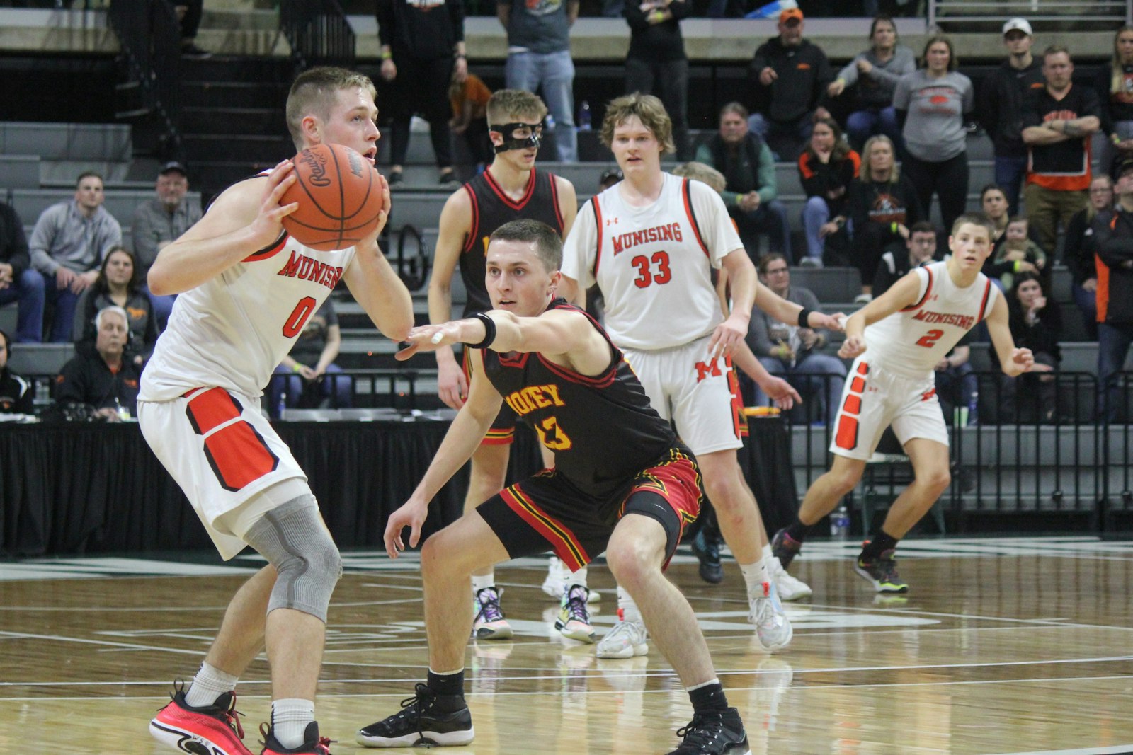 Cardinal Mooney senior Quentin Hillaker goes for a steal against Munising’s Kane Nebel. Munising won the contest, 55-44.