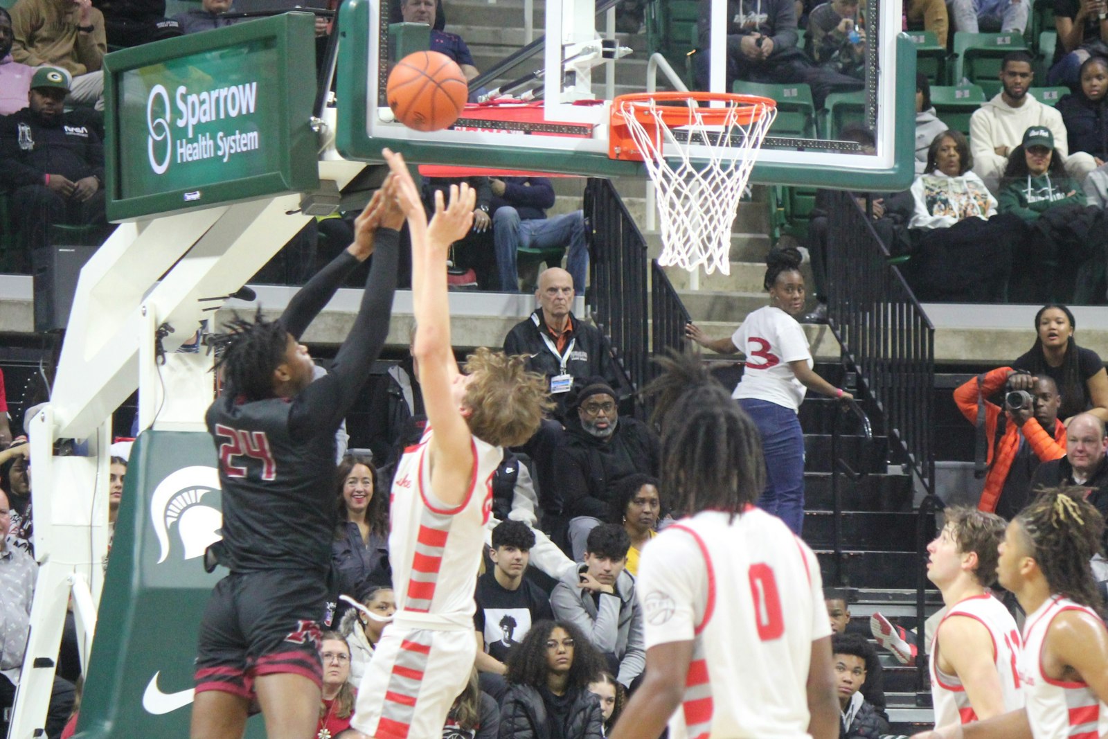 Junior center Mason Wisniewski goes up for a successful block of a lay-up attempt by Muskegon’s Terrance Davis.