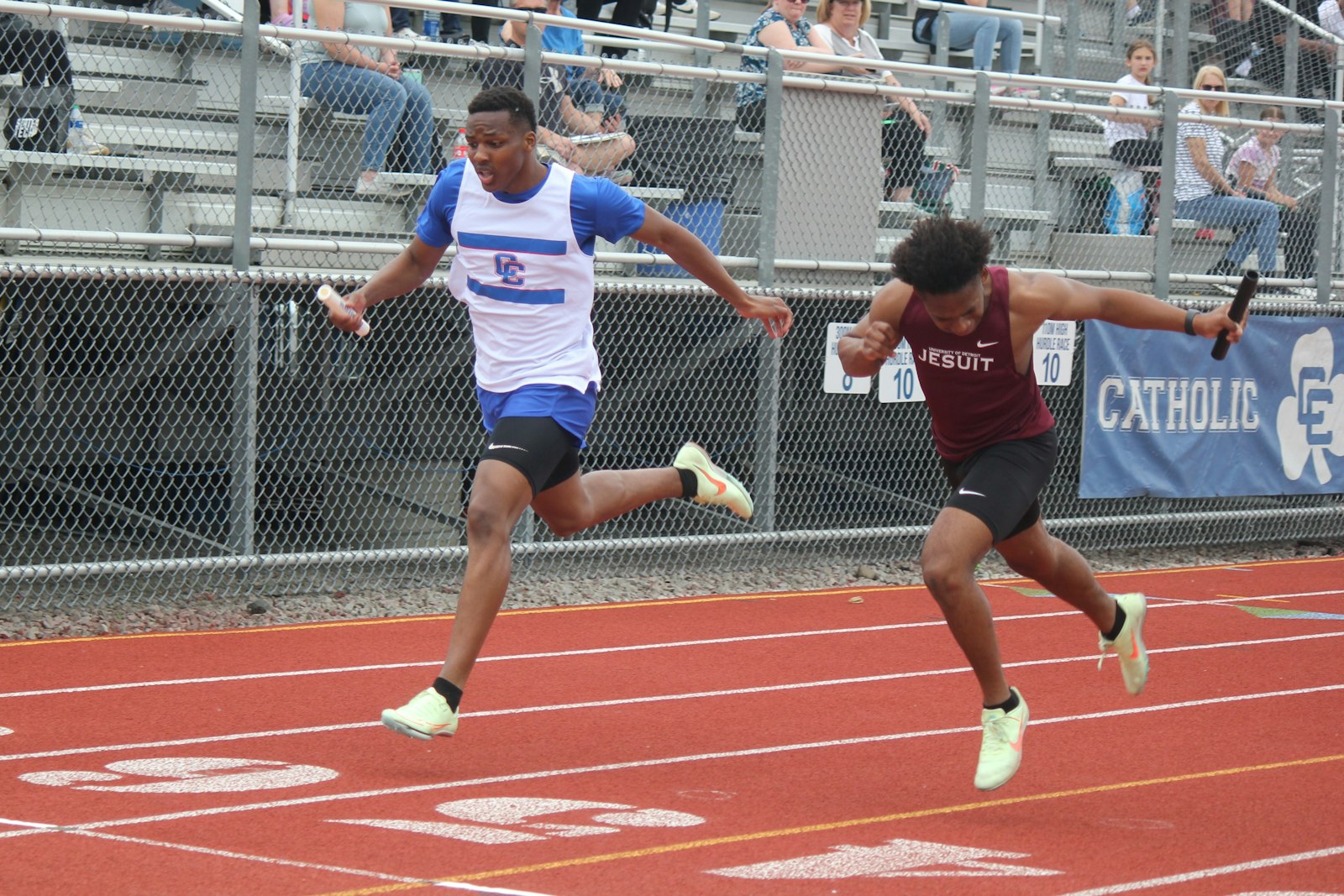 Catholic Central’s D.J. Lee edges ahead of University of Detroit Jesuit’s anchor runner at the finish of the 4x200-meter relay. The Shamrocks beat University of Detroit Jesuit by 2/1000ths of a second in the race.