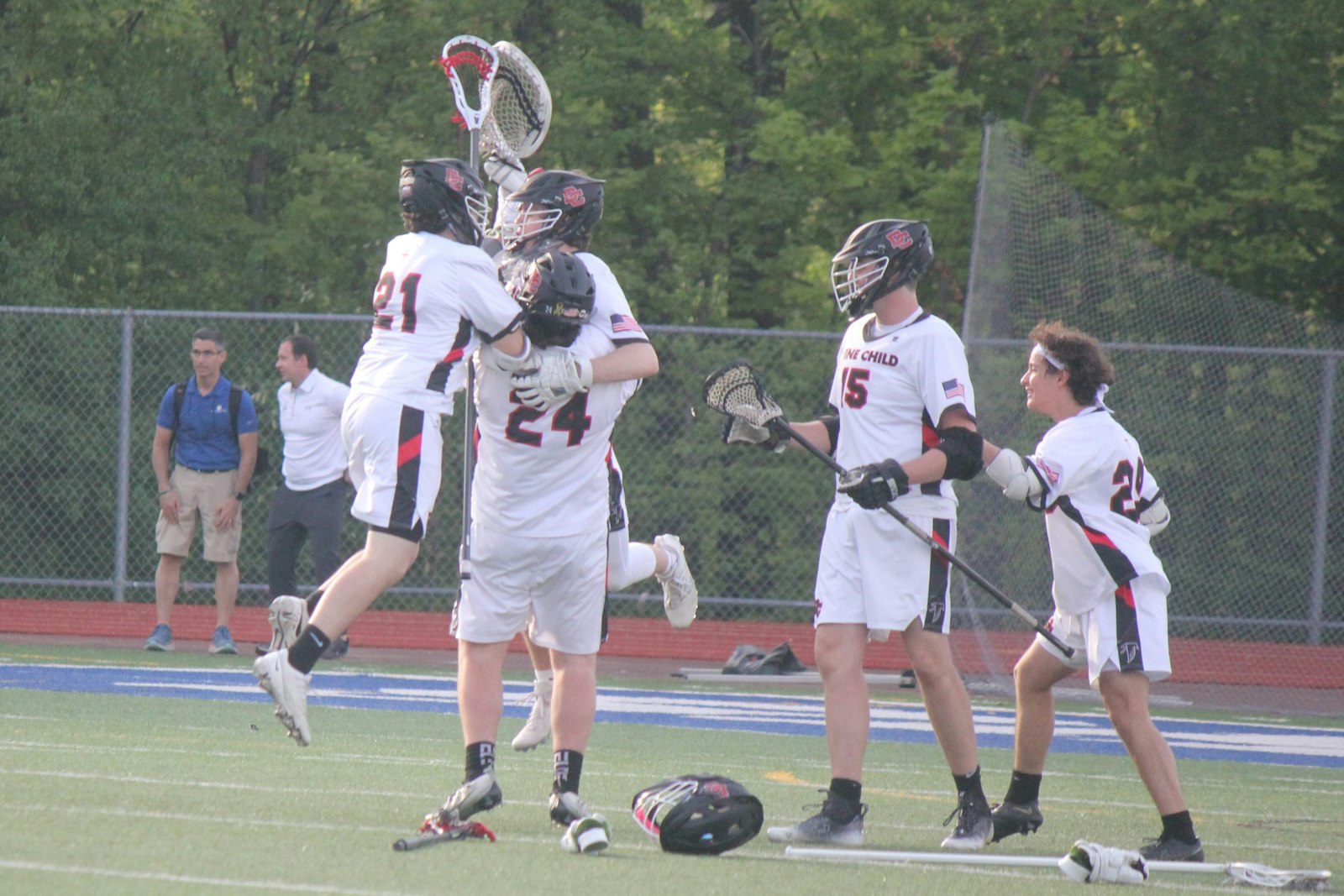 Divine Child players rush to congratulate goalkeeper Dylan Ross (center) after the final horn of the Falcons’ 18-10 victory over Ann Arbor Fr. Gabriel Richard. Divine Child celebrated its first Cardinal Division championship since 2018.