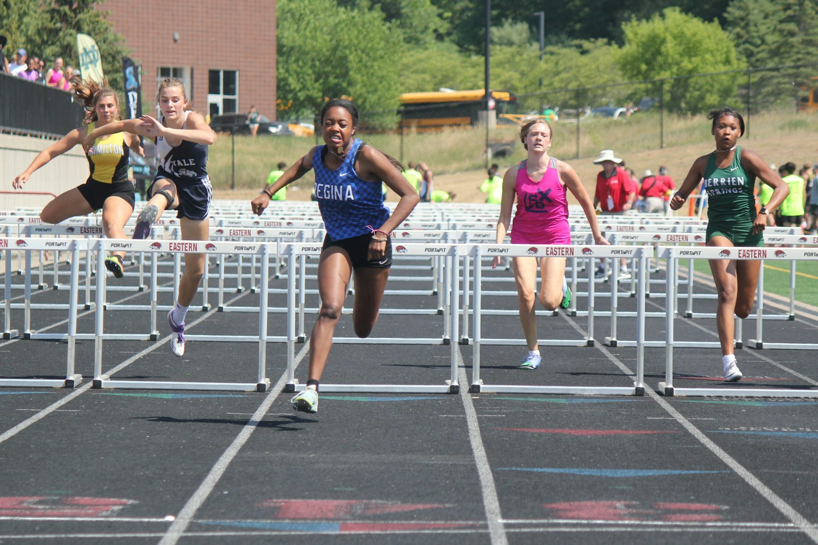 Warren Regina’s Ella Jenkins lunges for the finish line of the 100-meter high hurdles. She won the Division 2 competition at Ada Forest Hills Eastern in 14.47 seconds.