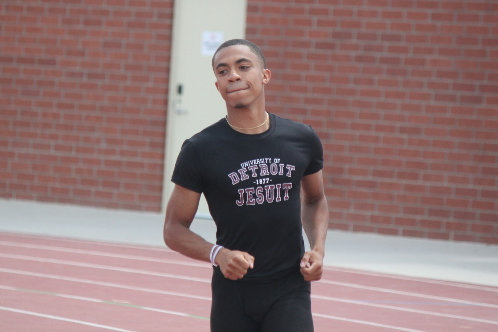 University of Detroit Jesuit’s Jaiden Reed celebrates his title in the 100-meter dash with a victory lap around the Rockford track. Reed clocked a state’s-best 10.74 seconds.