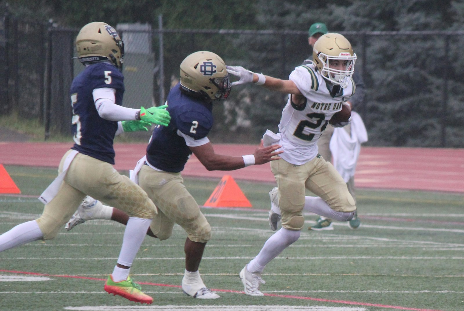 Notre Dame Prep’s Joey DeCasas stiff-arms a would-be tackler from Detroit Country Day while earning a first down. DeCasas was the leading rusher for the Fighting Irish, who defeated Country Day, 42-6.