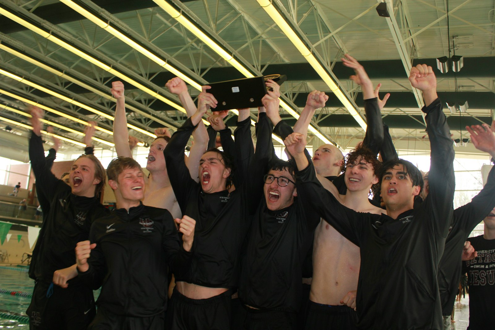 With the trophy finally in their hands, University of Detroit-Jesuit swimmers celebrate their first Catholic League swimming and diving championship since 1971. The Cubs bested the seven-team field Saturday at Waterford Kettering High School.