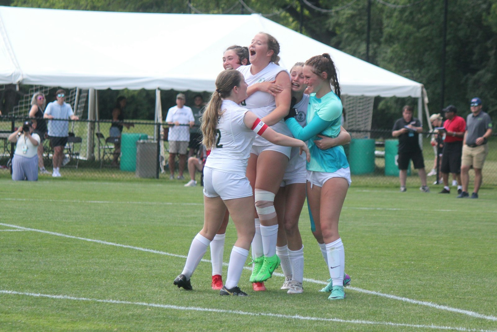 Brooke Lefere rushes to join Paityn Petitto, Paige Lefere, Kathleen Doane and Izzy Ematinger in on on-field celebration at the end of the shoot-out round.