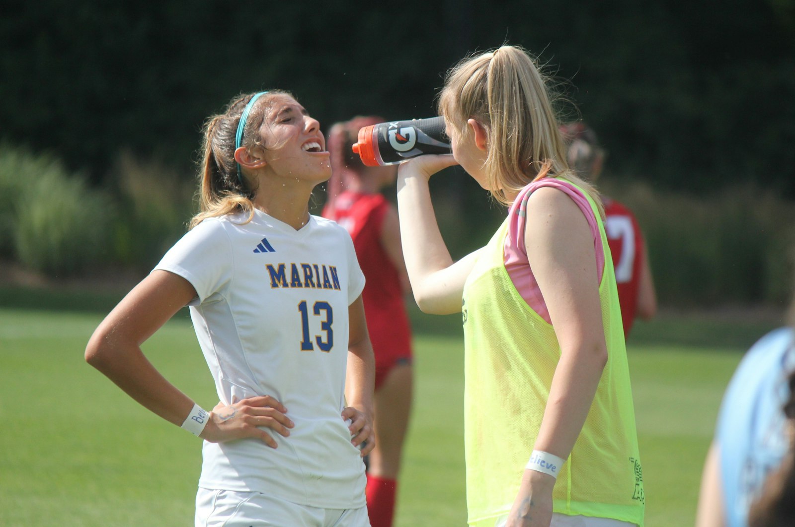 A teammate gives some much-needed liquid refreshment to Birmingham Marian’s Bella Musachio during a second-half timeout of the MHSAA Division 2 soccer championship game.